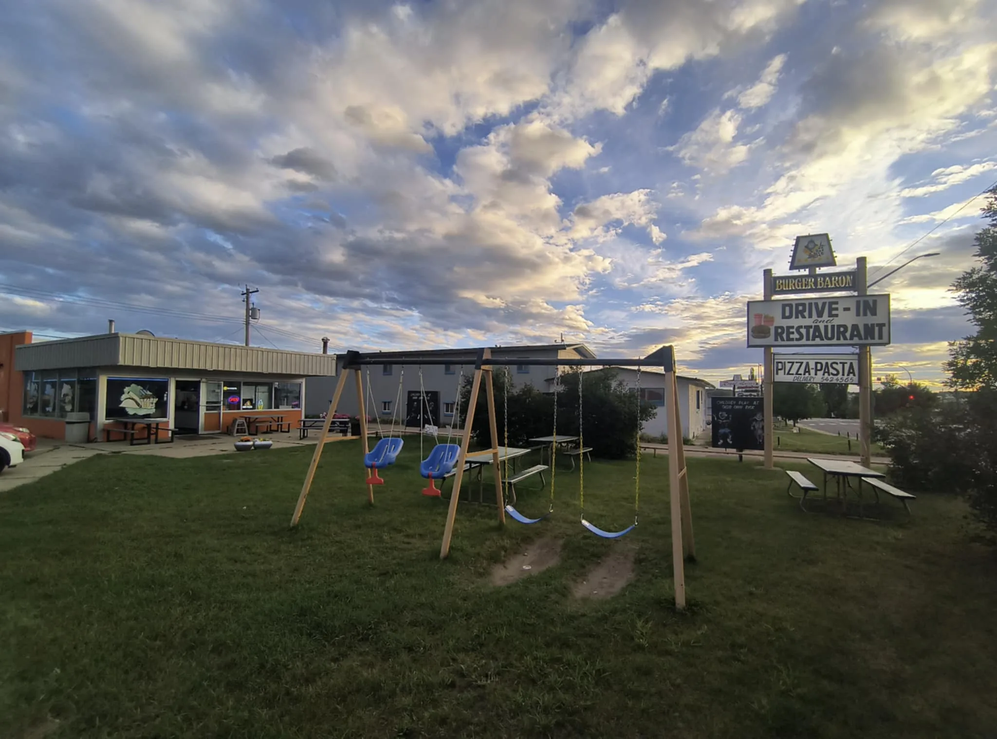 Burger Baron Playground – Drayton Valley The original Burger Baron restaurant in Drayton Valley, Alberta, with a swing set and picnic tables in the foreground