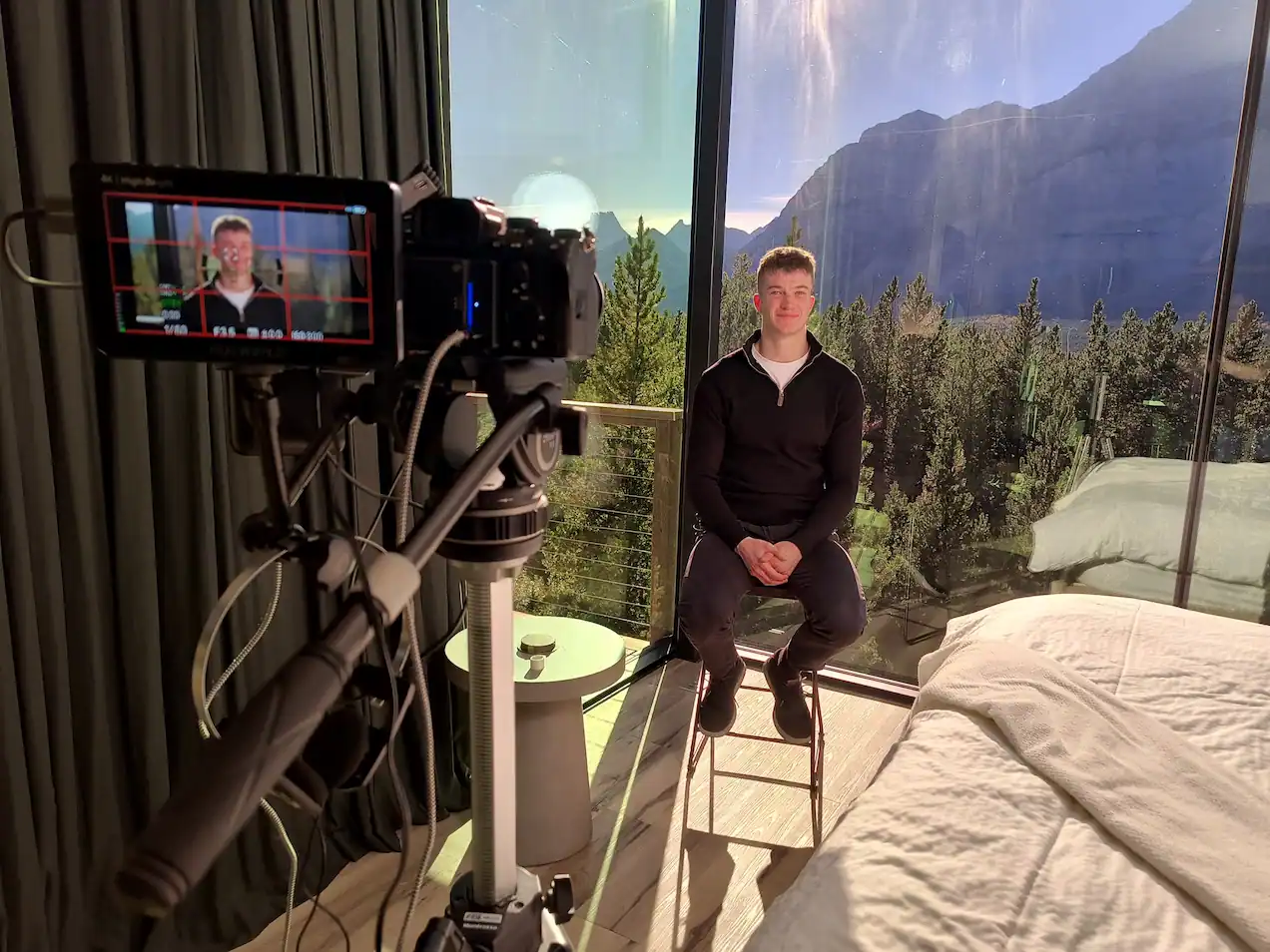 Behind-the-scenes view of a DMB Video interview shoot with a professional camera setup and a mountain backdrop